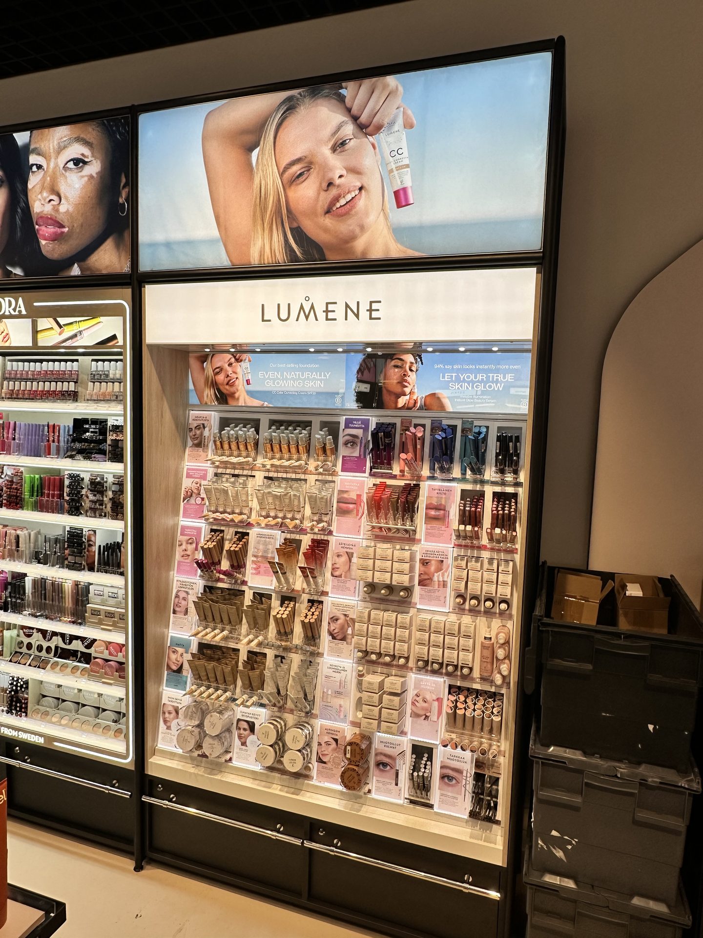 Large Lumene makeup display wall with backlit imagery and a full product grid