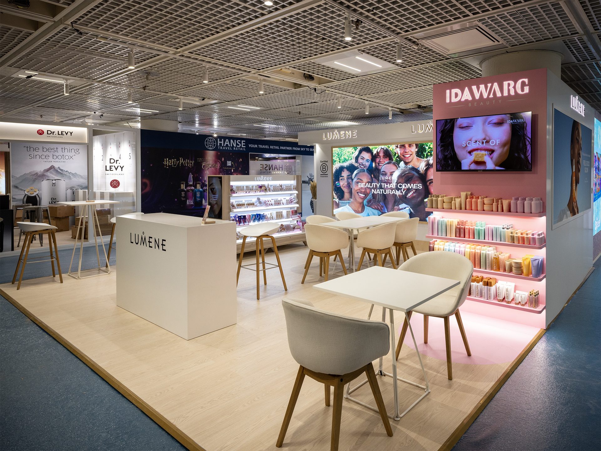 Neighbouring trade-fair booths with Lumene and IDAWARG signage and seating