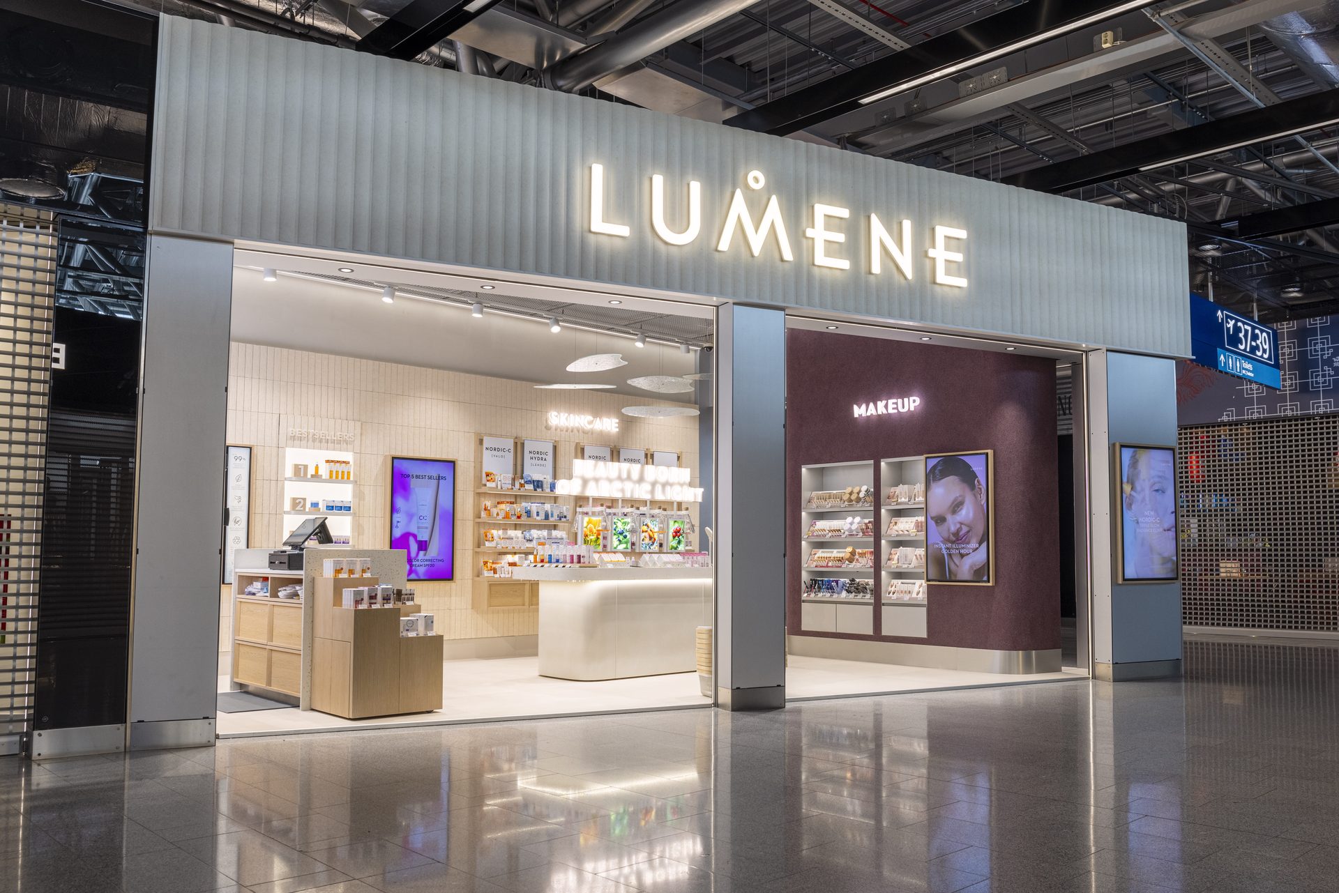 Lumene airport storefront entrance with illuminated logo sign